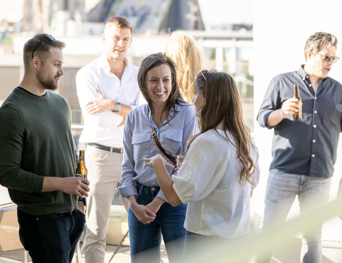 Cyclops team members chatting over drinks on the sunny rooftop terrace